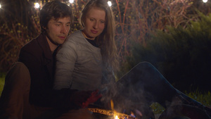 幸福的一对情侣坐在营火附近拥抱30秒视频