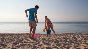 年轻家庭在海滩上踢足球30秒视频