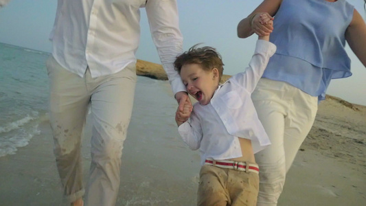 年轻家庭在海滩上奔跑视频