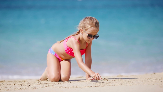 小女孩在沙沙滩上画画视频