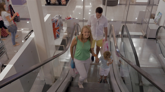 在购物中心有儿童骑车扶梯的年轻家庭视频