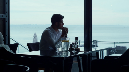 男人剪影看起来美丽的海景放松豪华全景餐厅视频