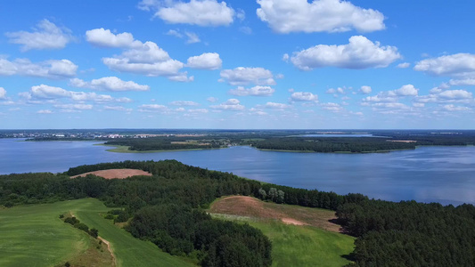 无人机从绿色草地上起飞观察蓝湖和白云的景象空中摄影视频