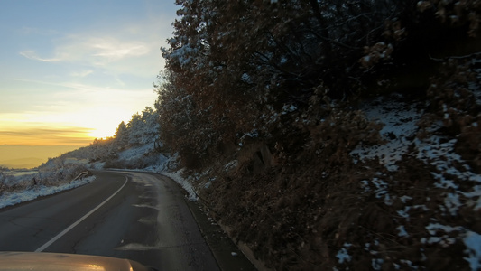 日落时冬林中雪覆盖道路上的山上驾驶小马视频