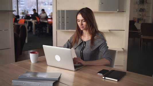 在办公室用电脑工作的女人穿着灰色的裙子视频