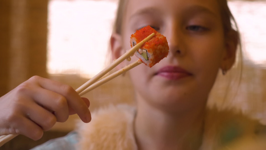 一个年轻的金发美女在咖啡馆吃寿司或在日本餐馆吃寿司视频