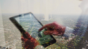 一个人用平板电脑的反射和后面的城市风景在后面25秒视频