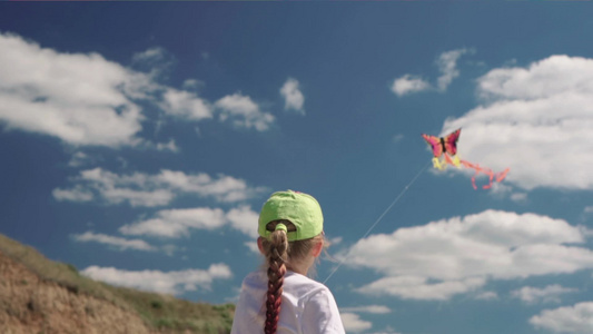 女孩在阳光明媚的夏日与风筝玩耍她控制着风笛在风中缓慢视频