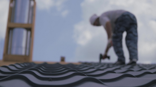 安装机把金属瓷砖打到房顶箱上屋顶建筑工作正常视频