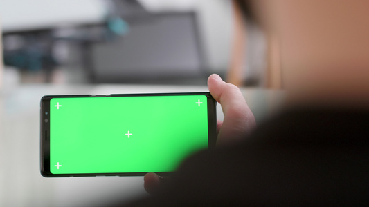 在智能手机上的绿色屏幕上暴露在肩部的镜头上视频