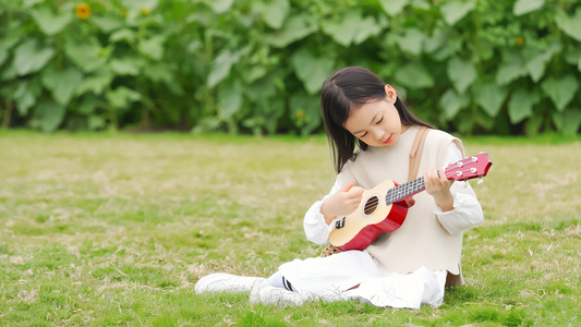 女孩坐在草地上弹尤克里里视频