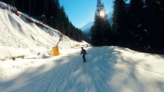 日出时滑雪机后斜坡上滑雪机的第一视角超慢动作视频