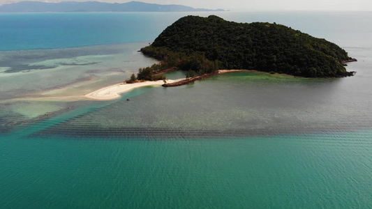 海中的热带岛屿在平静的蓝色大海中间的绿色热带岛屿的视频