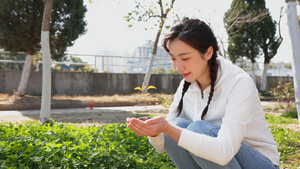 双手捧植物的青年女性9秒视频