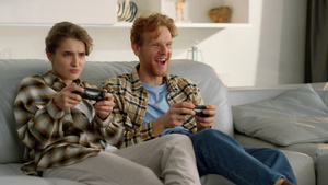 有竞争力的妻子在客厅里和微笑的姜黄色丈夫玩电子游戏30秒视频