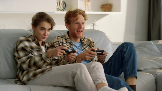 幸福的夫妻拿着操纵杆在电子游戏中输了视频
