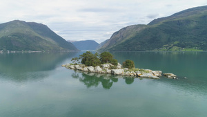 峡湾中的小岛背景为绿色山脉挪威卢斯特拉峡湾水中倒影20秒视频