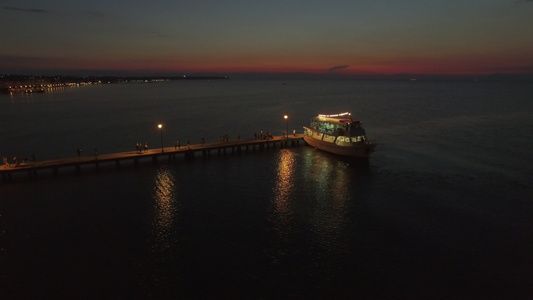 海面上浮舟的空中风景晚上人们从游艇上行走在海面上视频