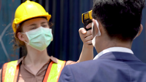 工厂工人戴面罩并使用温度计检查12秒视频