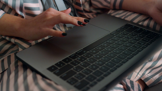 女士穿着睡衣特写使用笔记本电脑视频