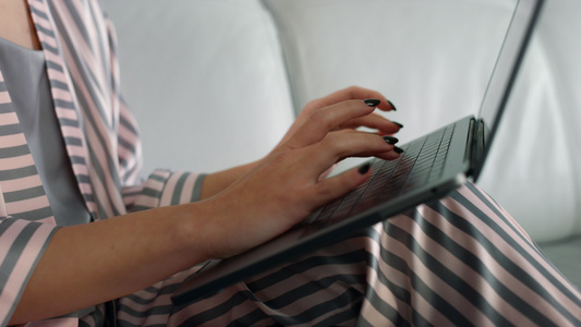 女人的手在家里使用笔记本电脑视频