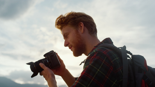 特写专业摄影师在日落山自然上拍照视频