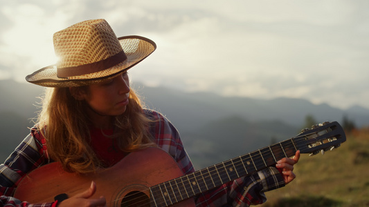 特写音乐女人在山中弹奏吉他乐器视频