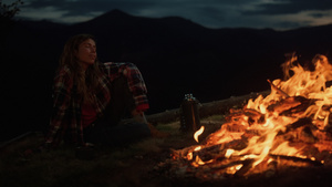 孤独的女人看着篝火在漆黑的夜晚燃烧19秒视频