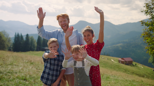 微笑的家庭挥手站在山上视频