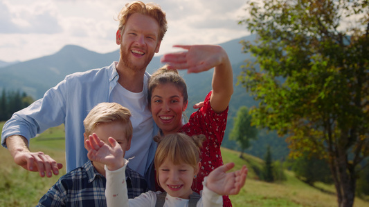 快乐的家庭在绿色的山上摆相机视频