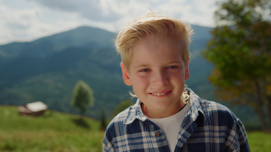 肖像快乐的男孩在山上看相机视频