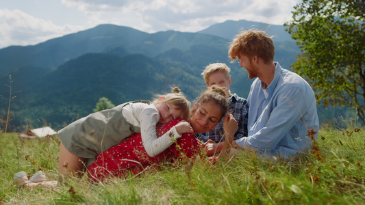 快乐的家庭在阳光明媚的日子里放松草地视频