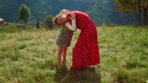 幸福的女人女儿拥抱在绿色的草地上19秒视频