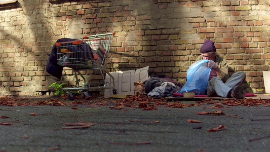 无家可归的人在垃圾袋里翻滚的景象视频