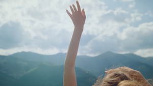 女孩享受阳光举起手来对着多云的天空特写19秒视频