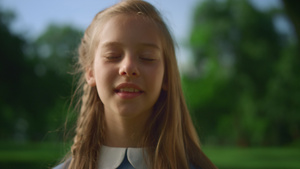 微笑的金发小女孩独自在公园特写镜头中16秒视频