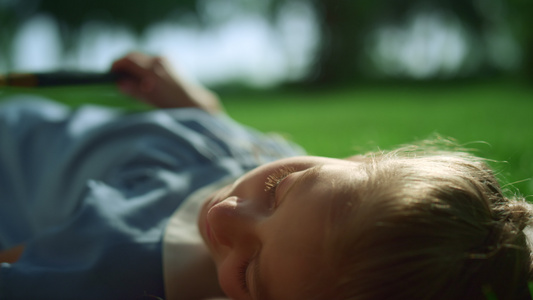 梦幻般的昏昏欲睡的女孩躺在公园特写镜头的金色阳光下视频