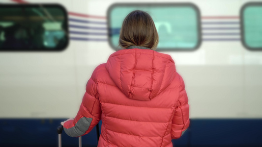 年轻女子站在站台平台上等待她的火车视频