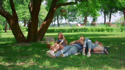 放松的家庭躺在绿草上野餐视频