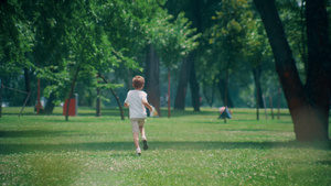 阳光明媚的日子里精力充沛的小男孩在郁郁葱葱的田野上奔跑9秒视频