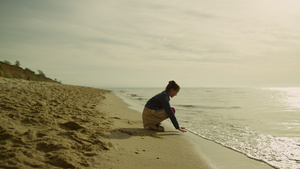 小孩在日落海滩上抚摸着海浪9秒视频