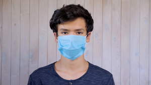 戴着医疗面罩的年轻人看着相机爆发戴面具的15岁男孩14秒视频