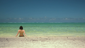 热带沙滩青年妇女坐在水边20秒视频
