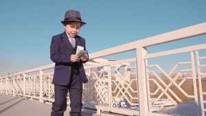 穿黑西装戴帽子从桥上扔钱的年轻商人男孩22秒视频