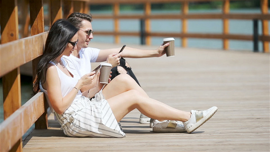 一对在公园使用智能手机的快乐情侣视频