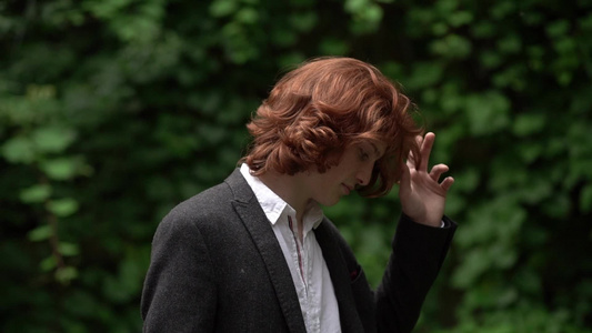 那个穿西装长发的红发男子穿着西装在花园里视频