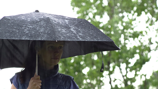 女孩在雨中的黑伞下视频