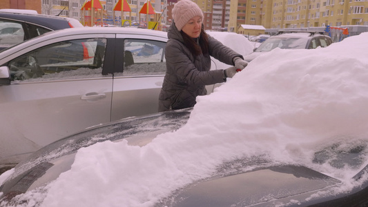青年女司机在公用公寓停车场洗车雪的年轻女司机视频