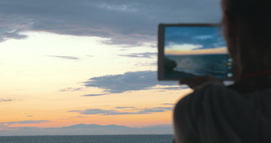 女人拍下美丽的海景和夜空的照片15秒视频