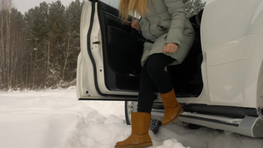 青年女司机从冬季森林风景的停车场出来驾车视频
